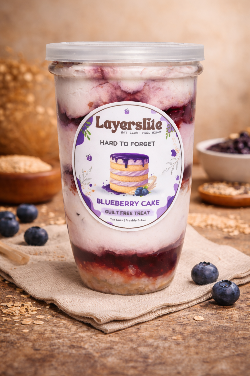 Layerslite blueberry cake dessert jar on a wooden surface with blueberries around