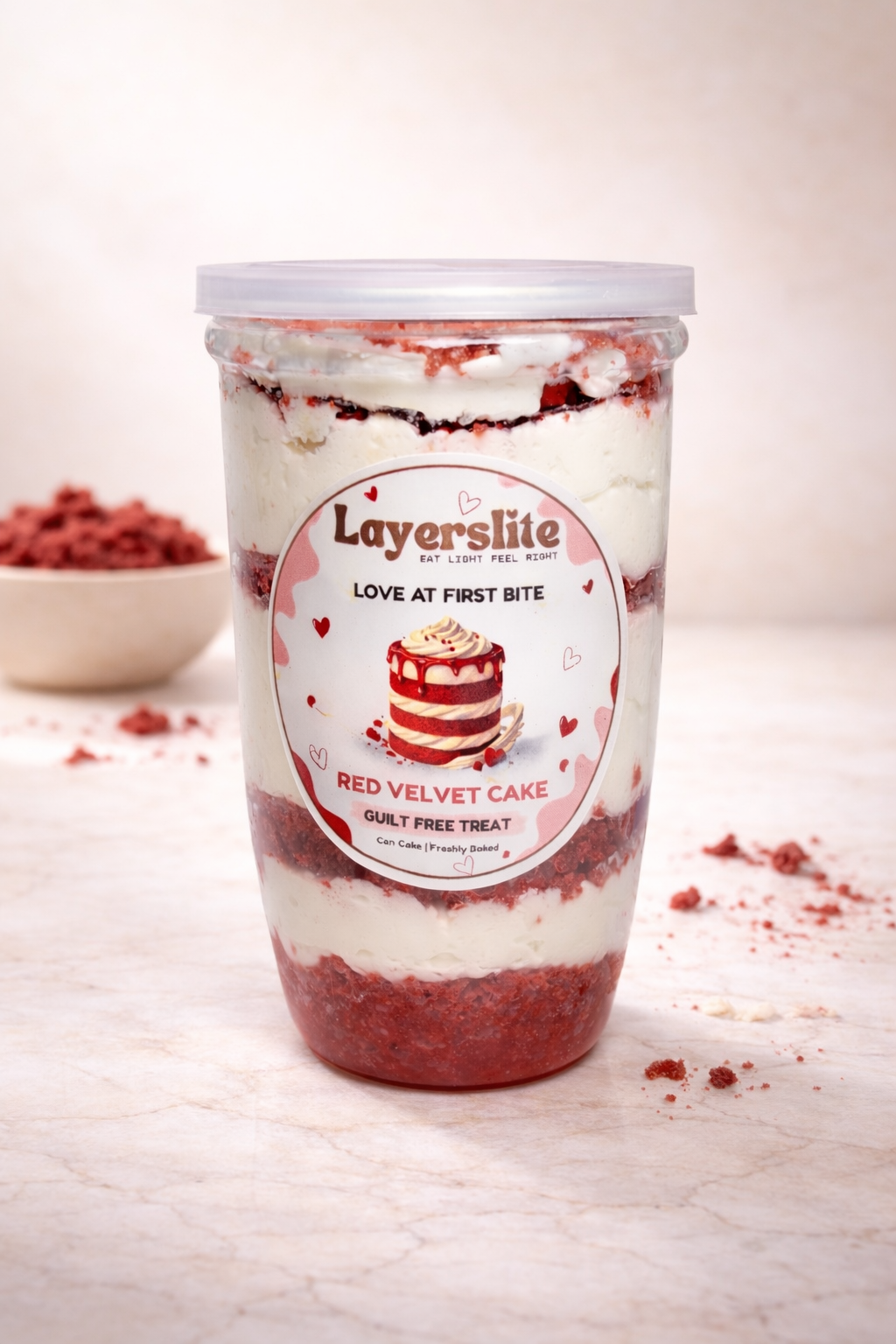Red velvet cake in a container with 'Layerslite' branding on a light background